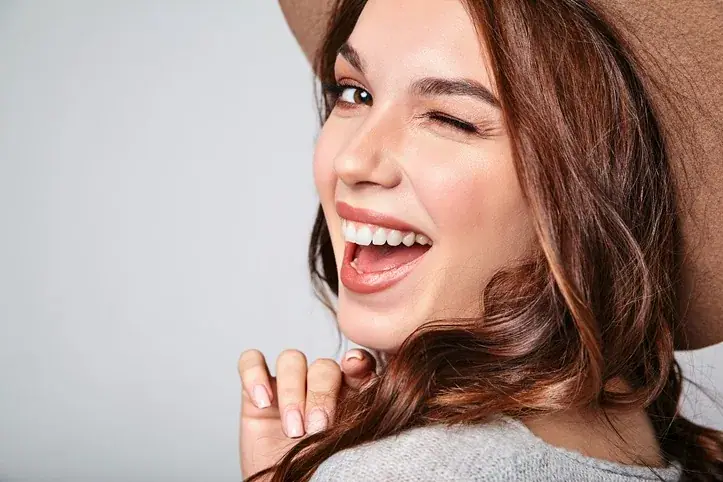 Joyful young woman with a radiant white smile — cosmetic dentistry results from Texas Dental Center in Houston.