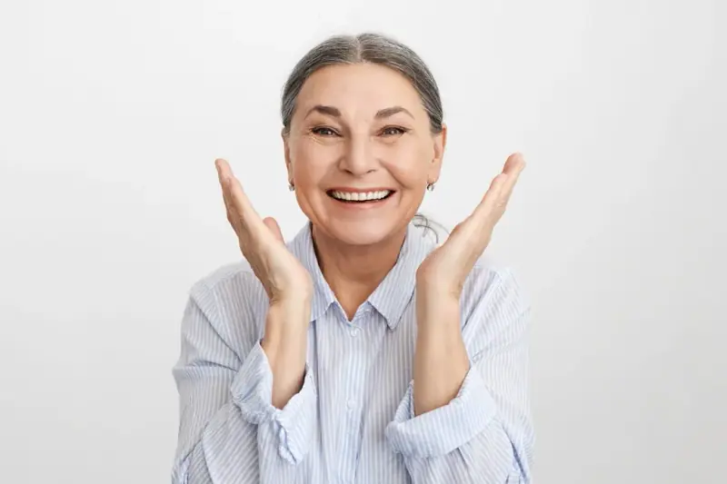 一位年长女士对修复后的全口种植笑容感到由衷开心。