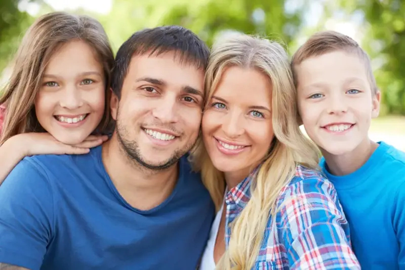 Happy family smiling together, representing successful orthodontic results at Texas Dental Center.